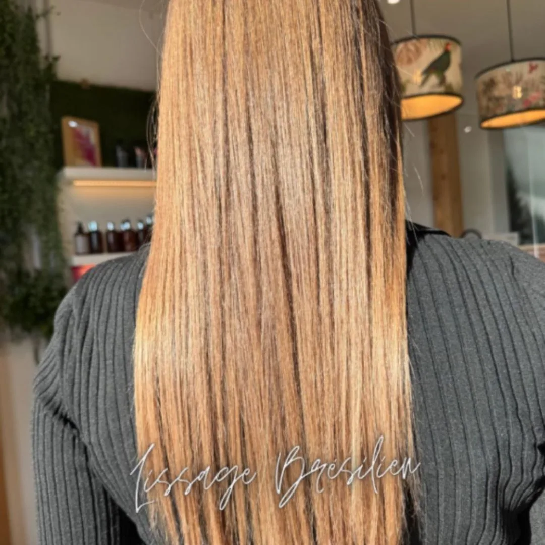 Cheveux blonds longs et lisses vus de dos, mention Lissage Brésilien